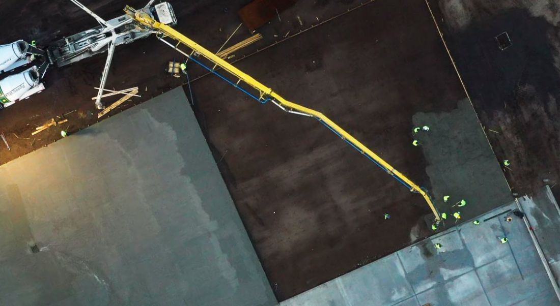 Boom reach across a pavement section, shot from above