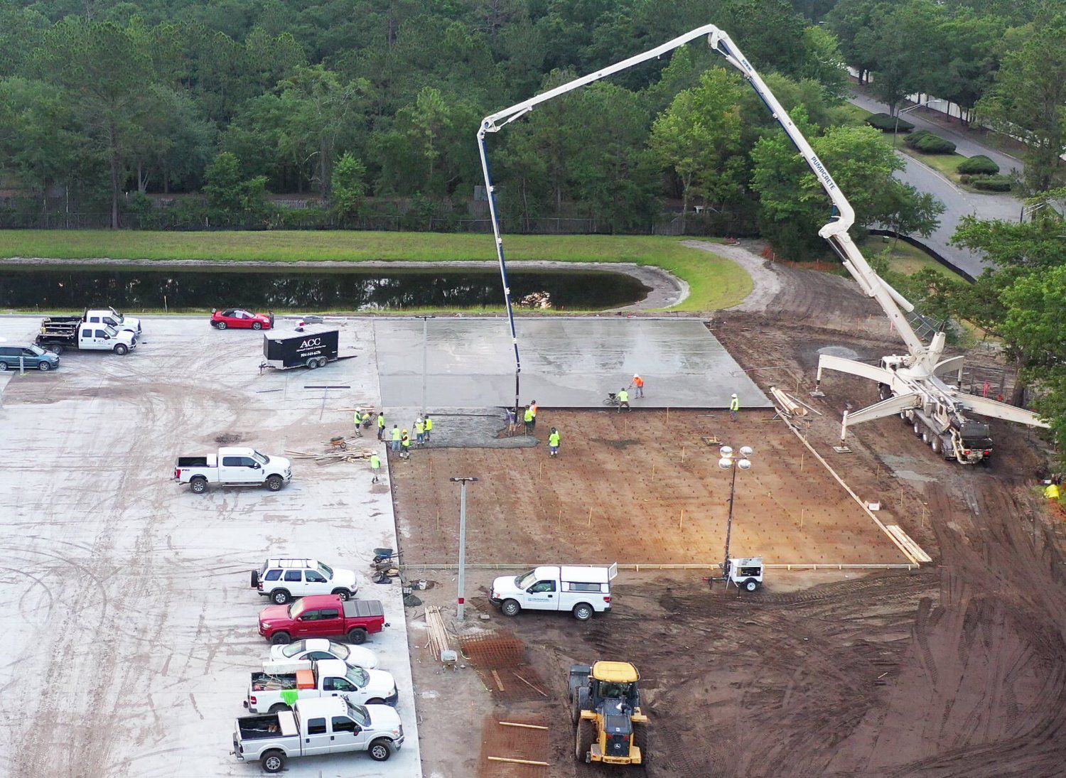 Boom pump placing a large pavement section on a working commercial site