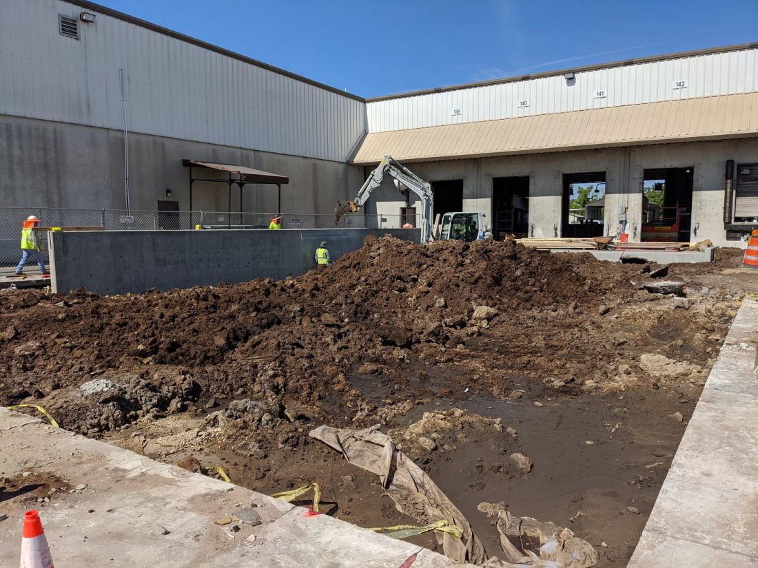 Old slab broken out and removed behind a live building